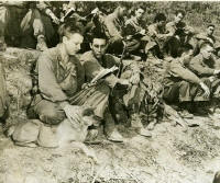 A group of military men sitting on a hillside