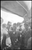 A group of military men crowding together on a ship deck